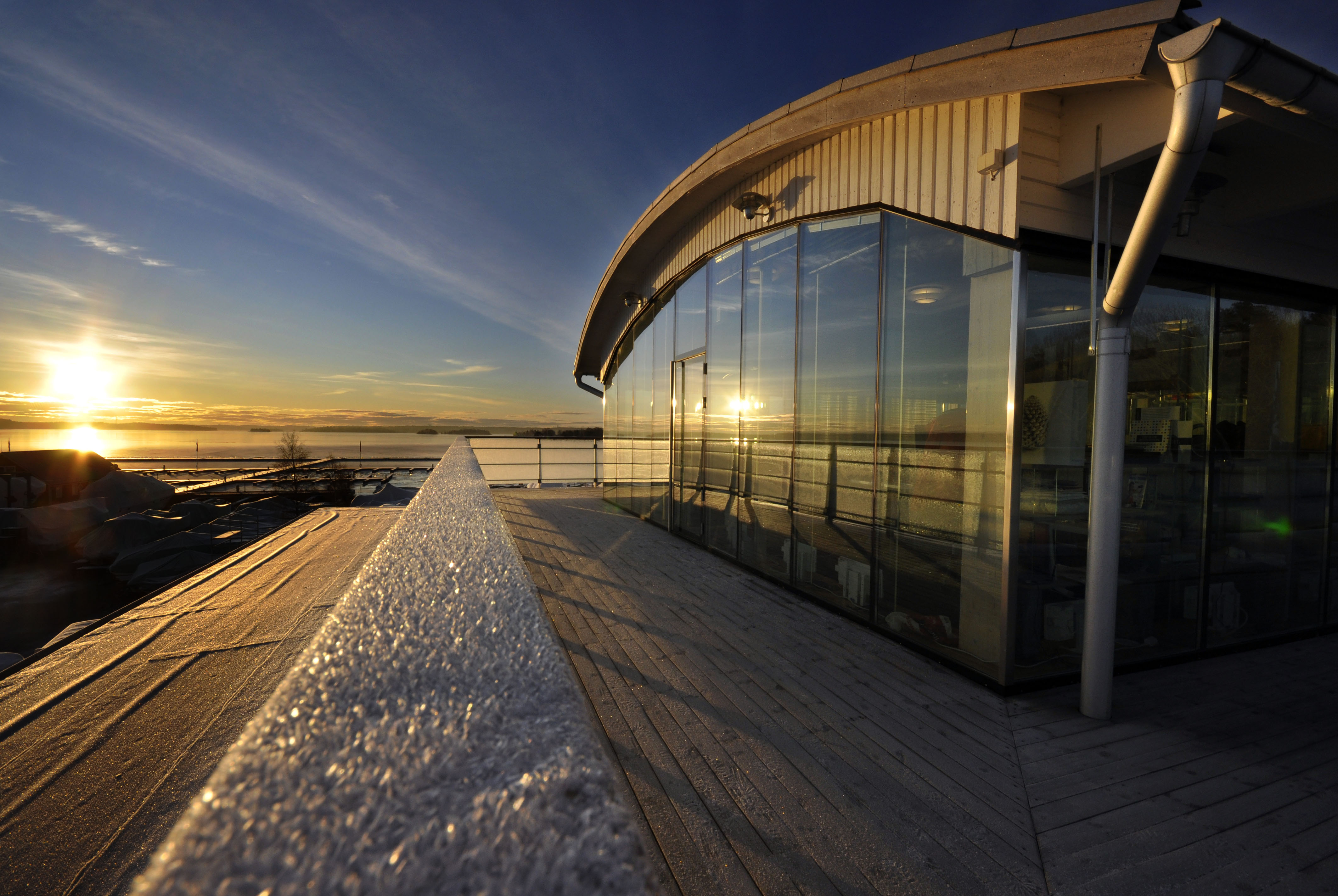 Solnedgång i vinterlandskap med ett hus förgrunden.